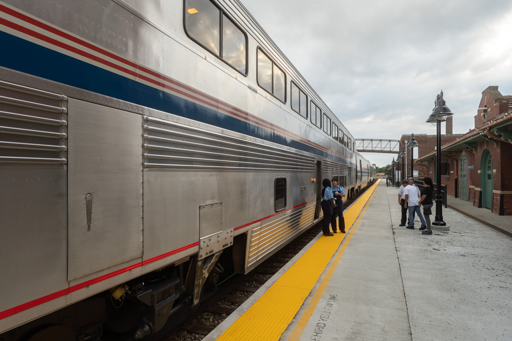 An Amtrak Superliner at a short stop during daytime